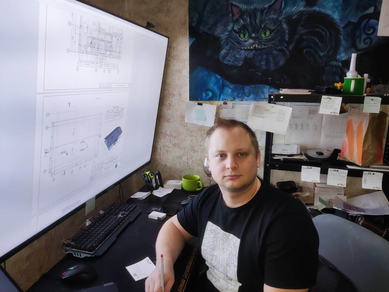 Инженер компании за рабочим местом с проектами систем отопления на экране. Консультация по проектированию отопления для частных домов.